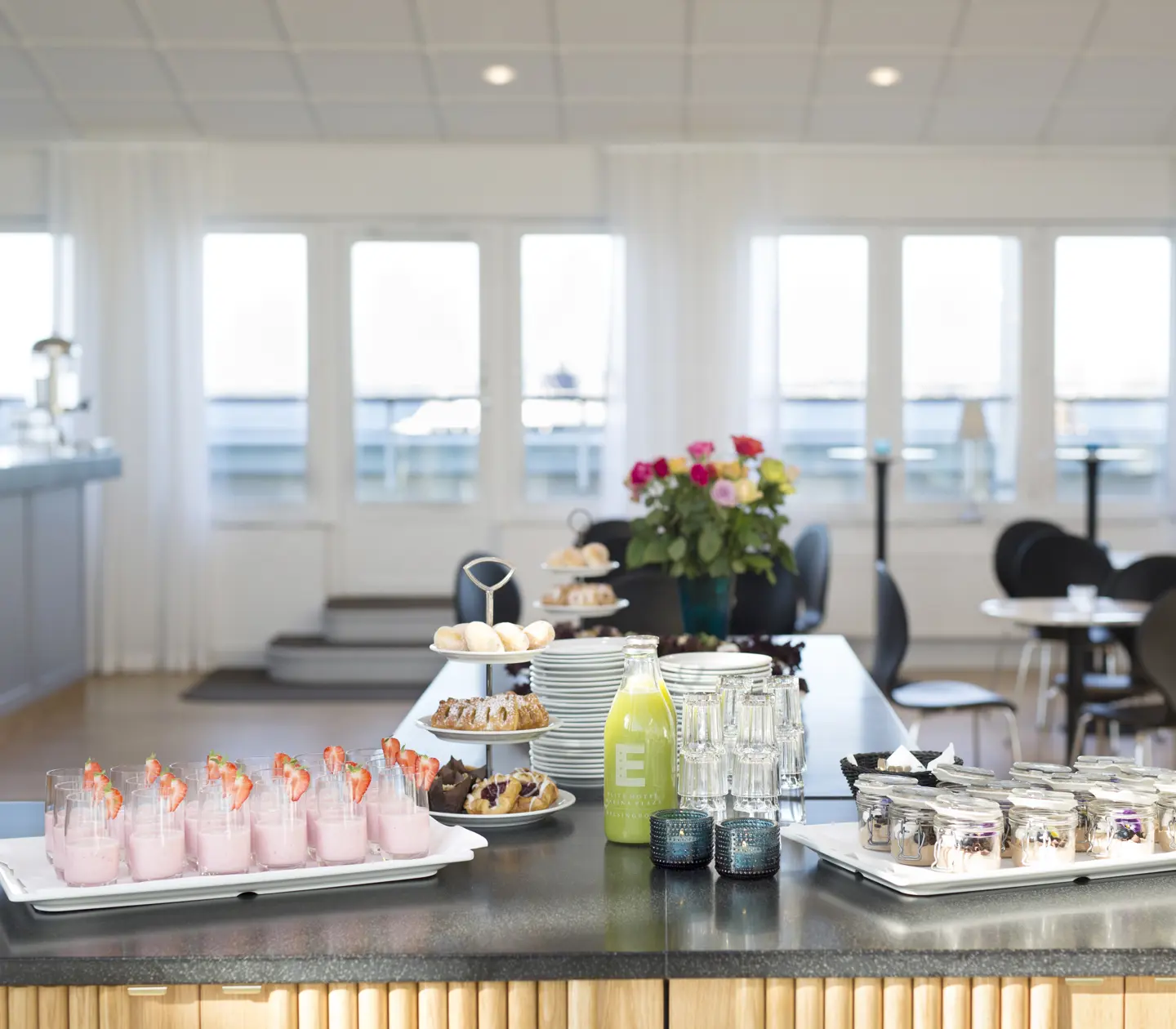 Konferensfika uppdukad på bord med matgrupper i bakgrunden