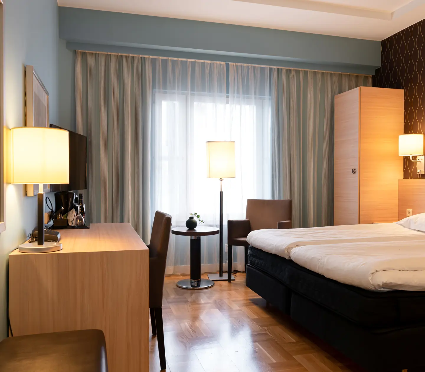 Mysigt hotellrum med säng, skrivbord och fönster