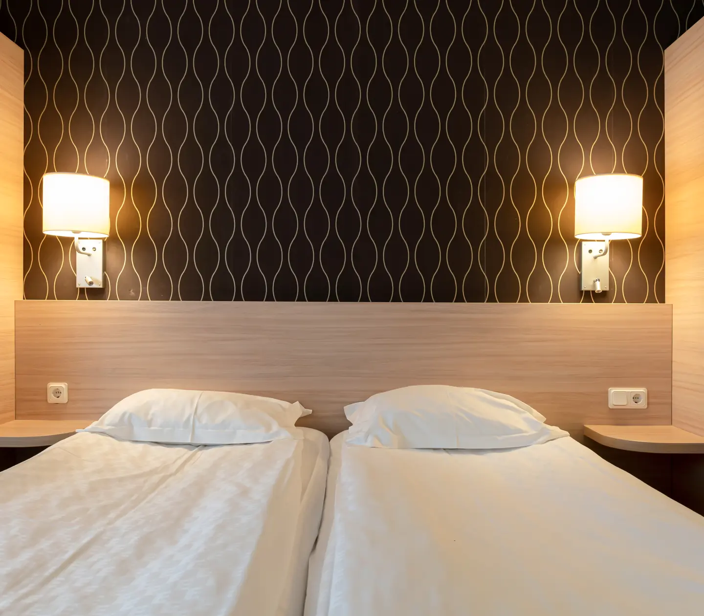 Mysigt hotellrum med säng, garderober och sänglampor