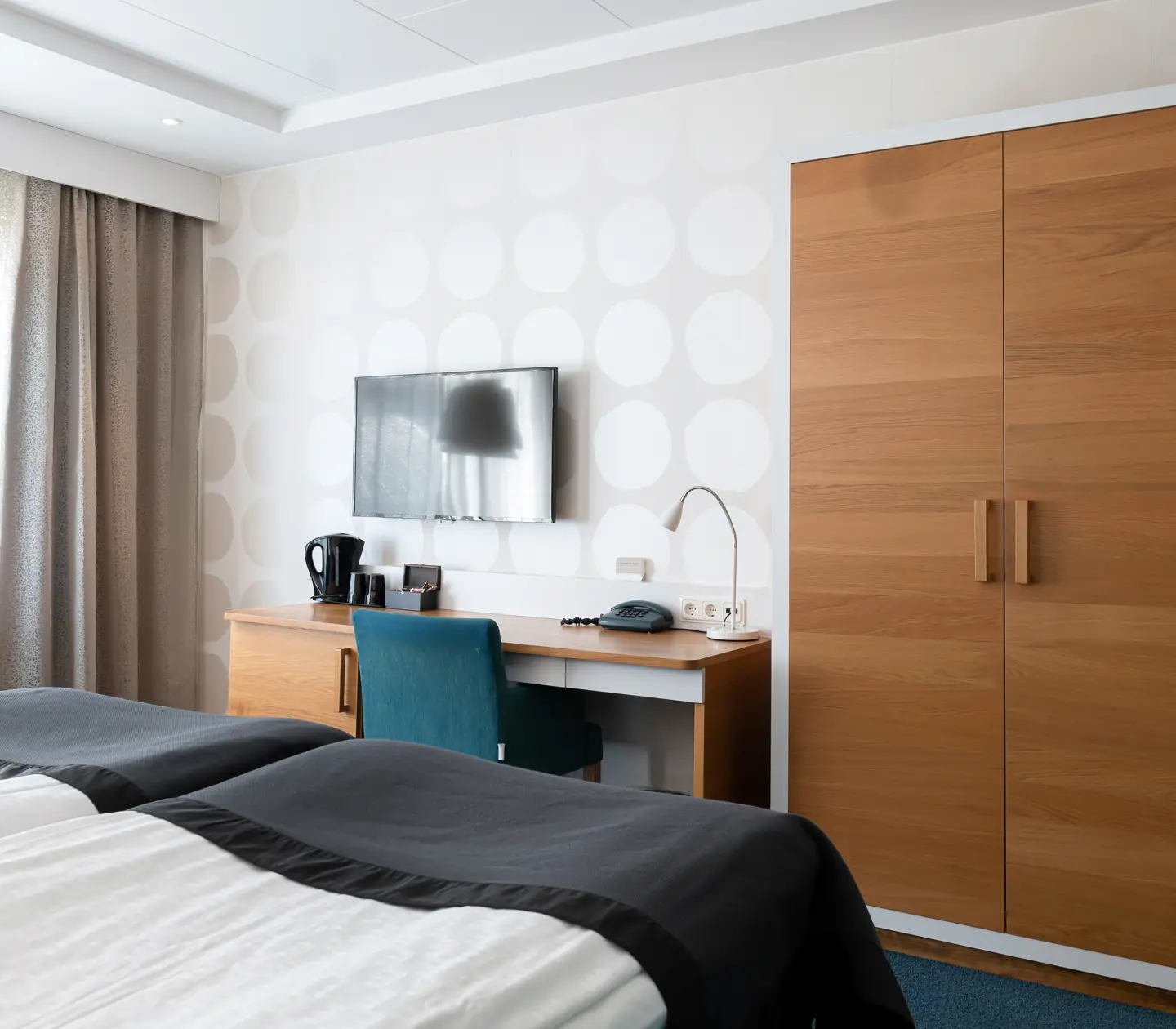 Hotellrum med skrivbord, garderob och tv
