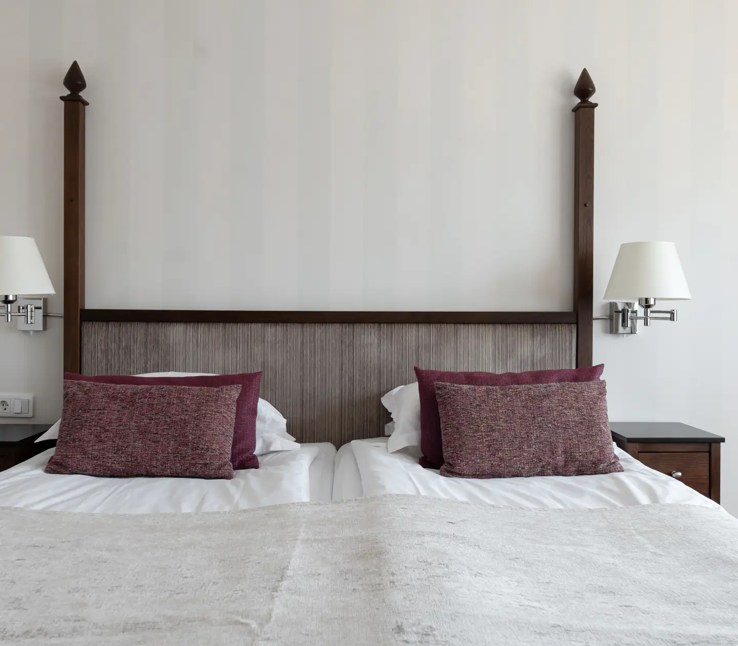 Ljust hotellrum med dubbelsäng, sängbord och sänglampor