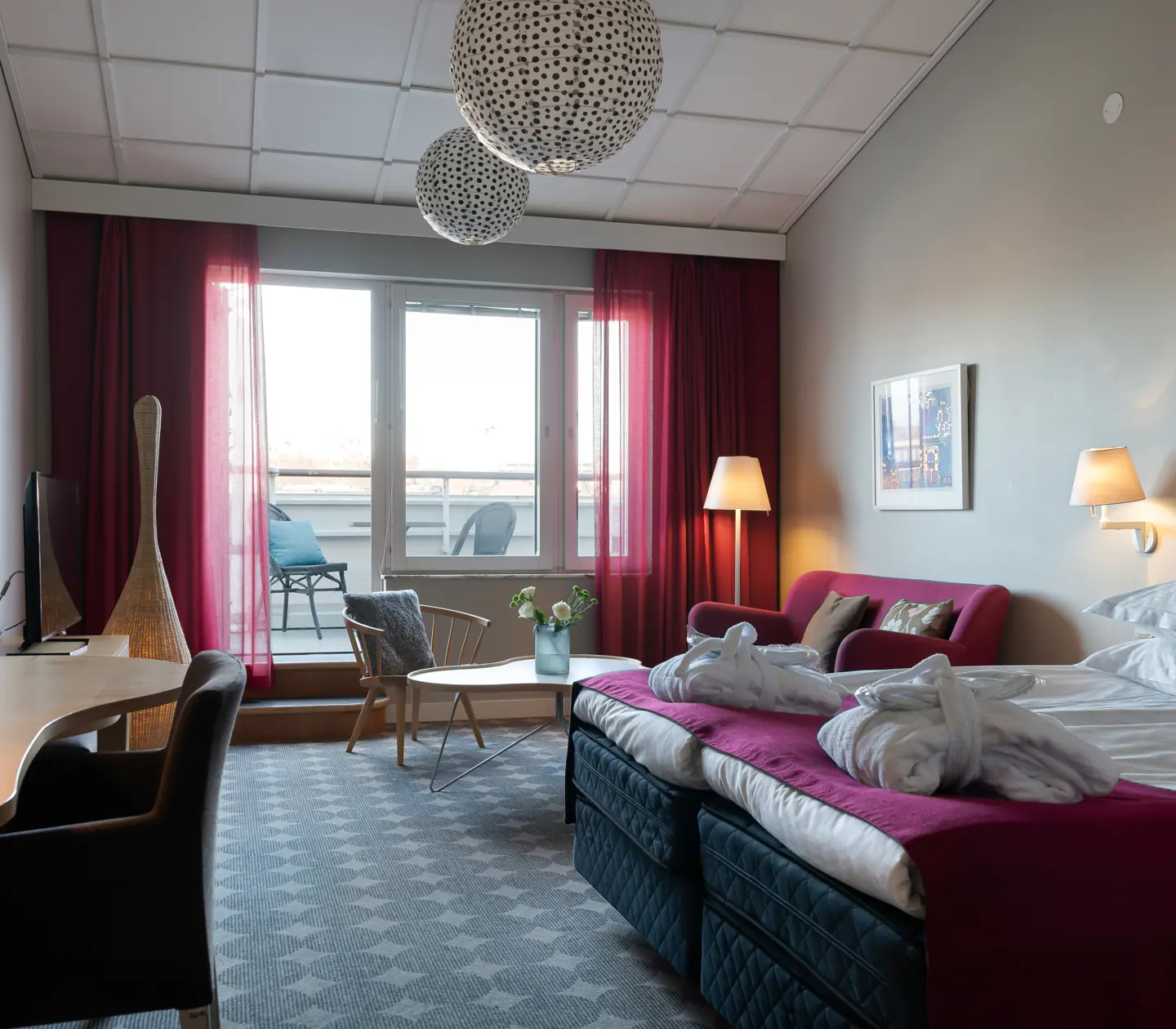 Mysig hotellsvit med soffa, tv och balkong