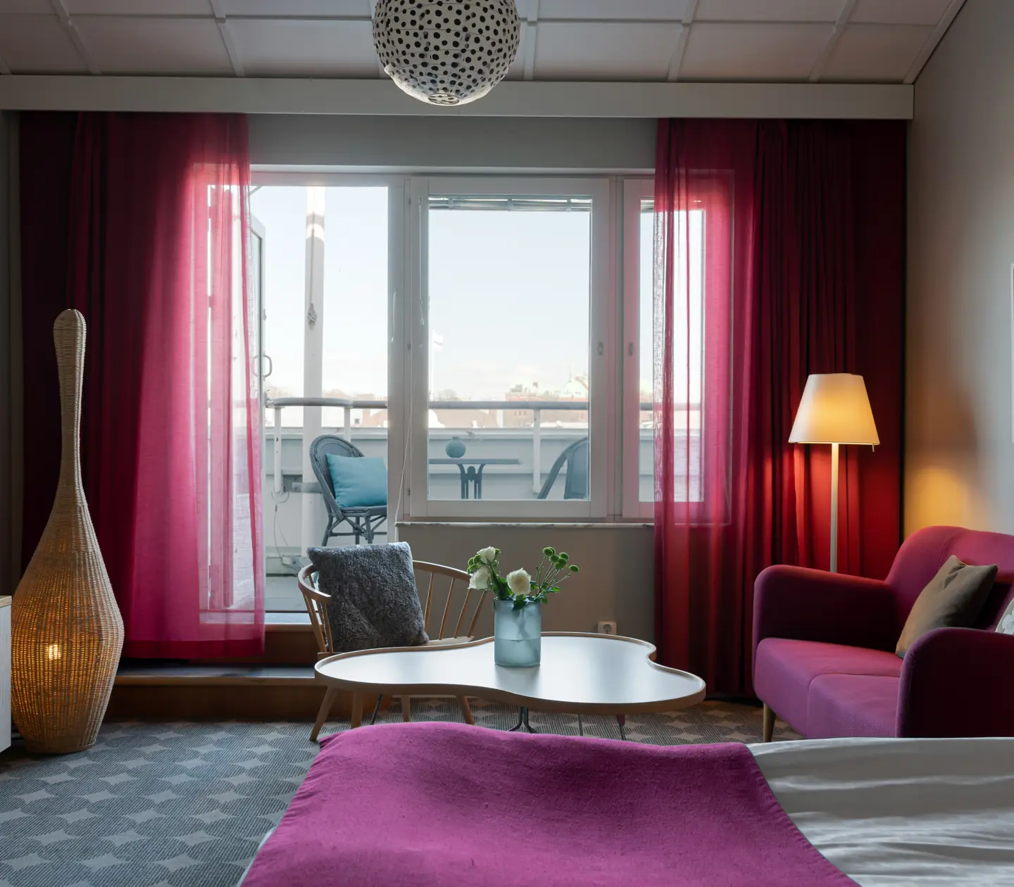 Mysig hotellsvit med soffa, säng och mörk sänggavel