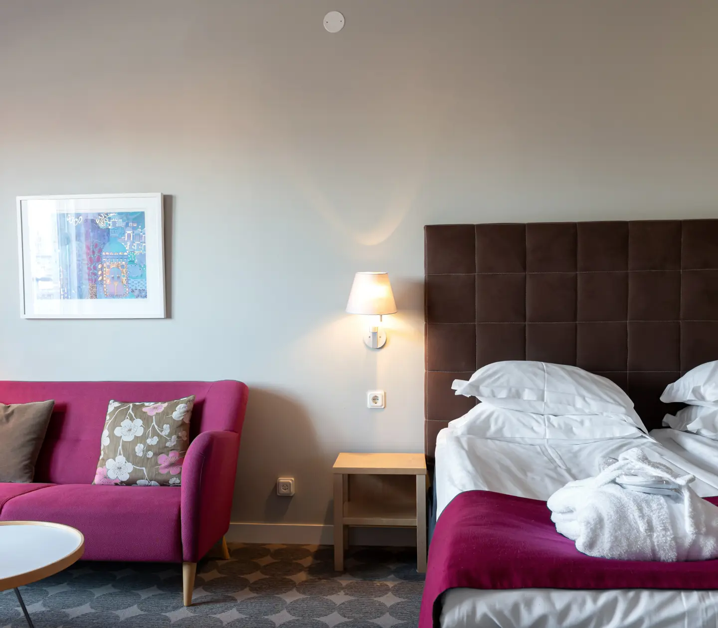 Mysig hotellsvit med soffa, säng och balkong