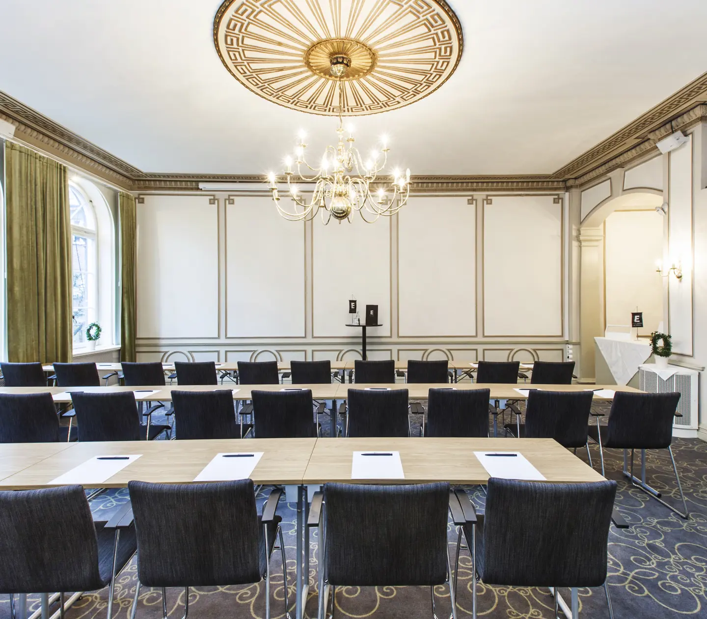 Konferensrum med många stolar och pampig lampa