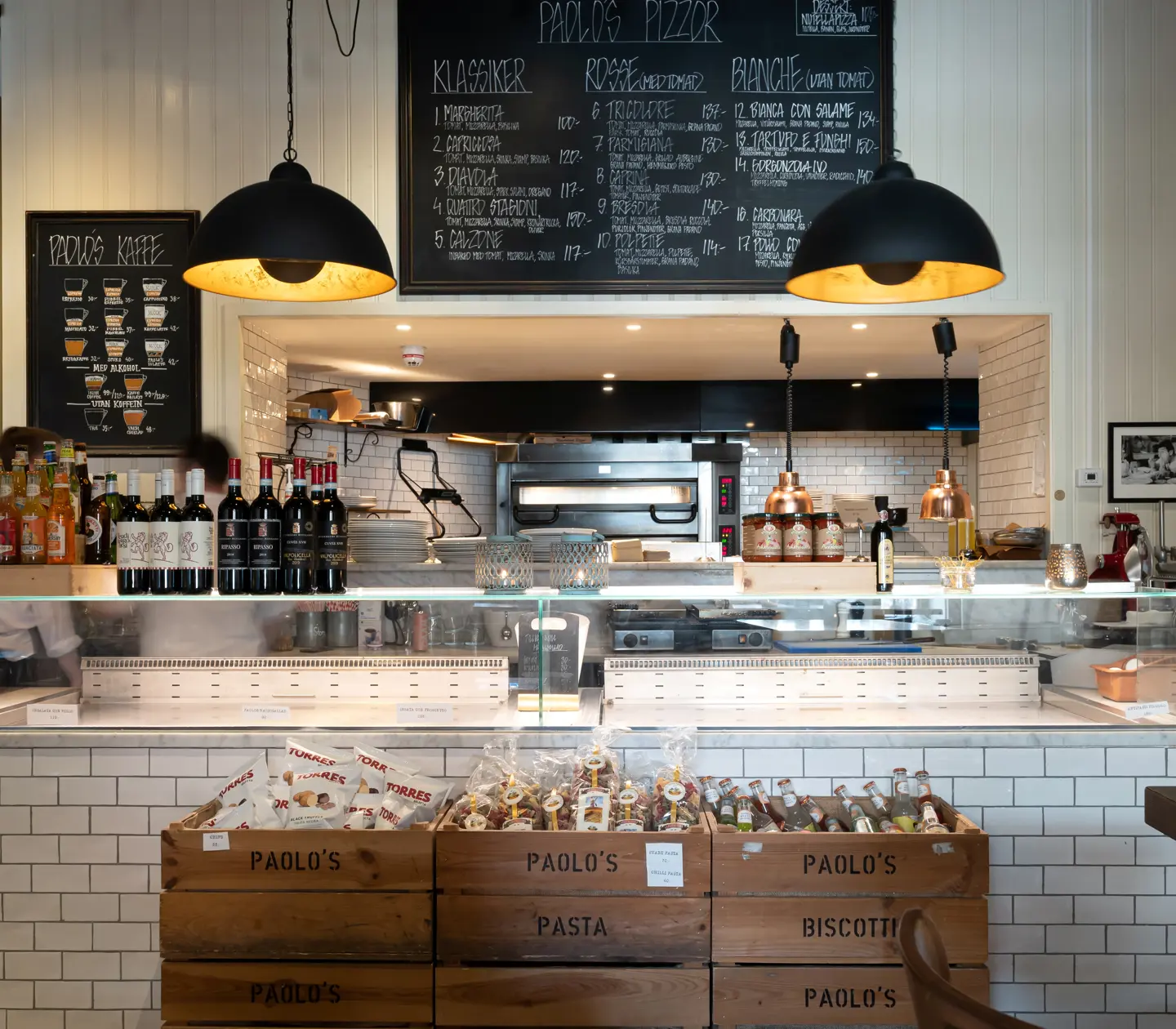 Ljus restaurangmiljö med menyer, kylar och flaskor
