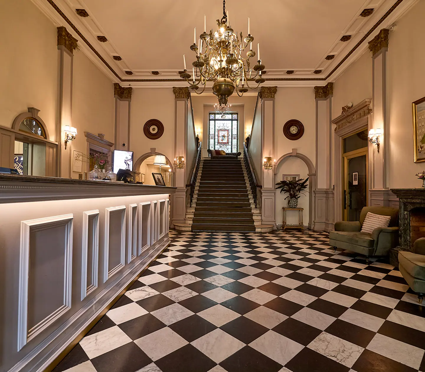Hotellobby med schackrutigt golv och trapp