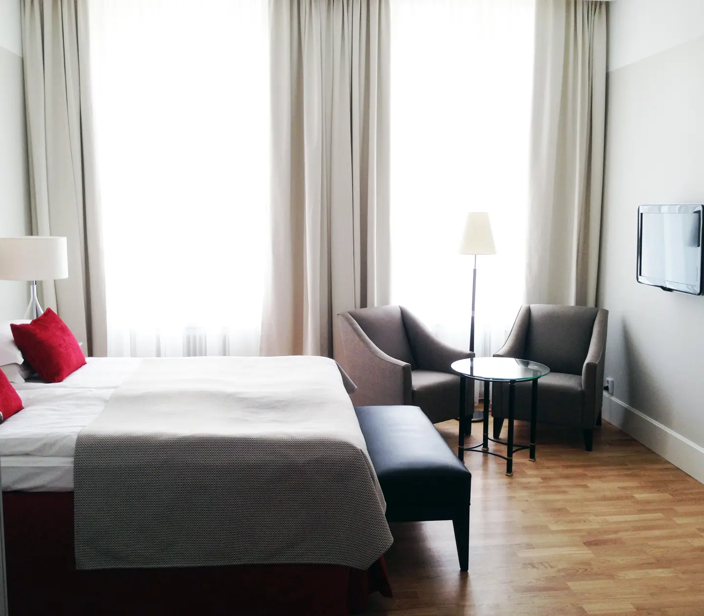 Hotel room with double bed, armchairs and wardrobes