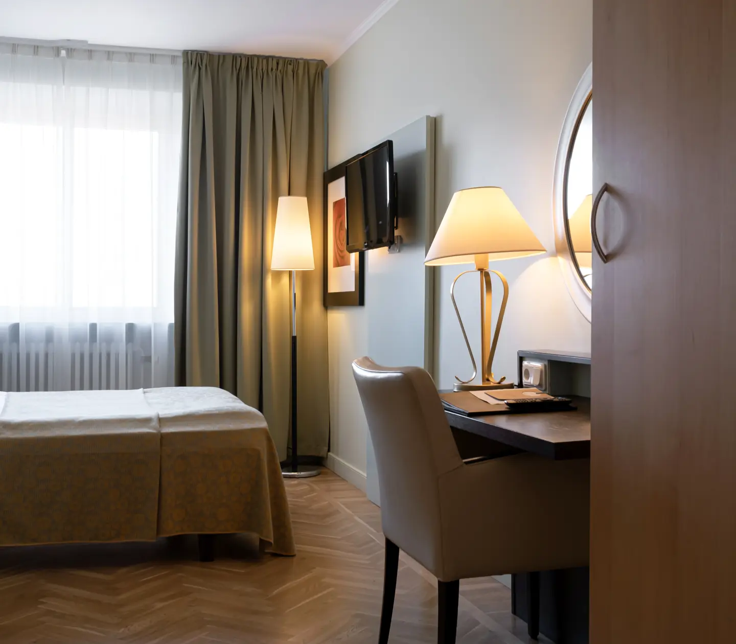 Hotellrum med säng, skrivbord och fönster