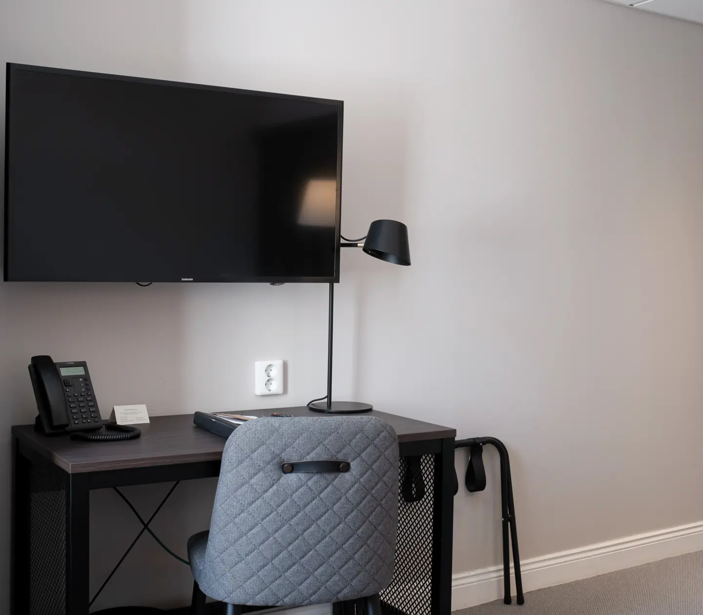 Hotellrum med skrivbord, tv och spegel