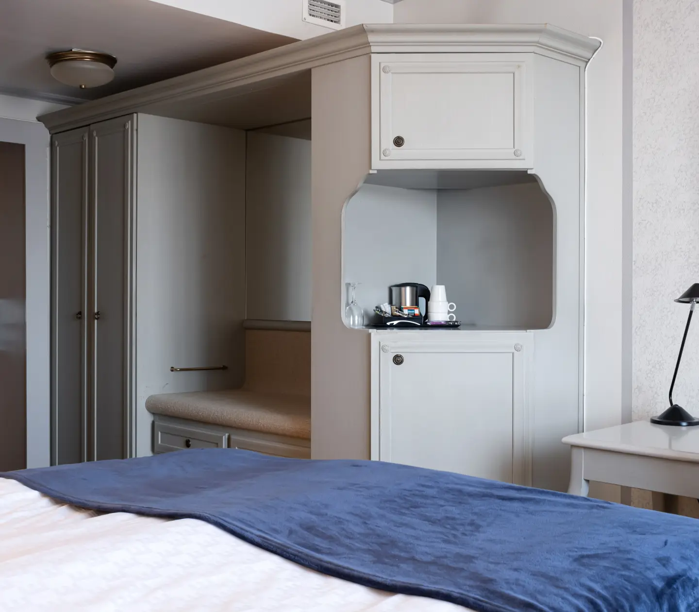 Hotellrum med säng, garderob och skrivbord
