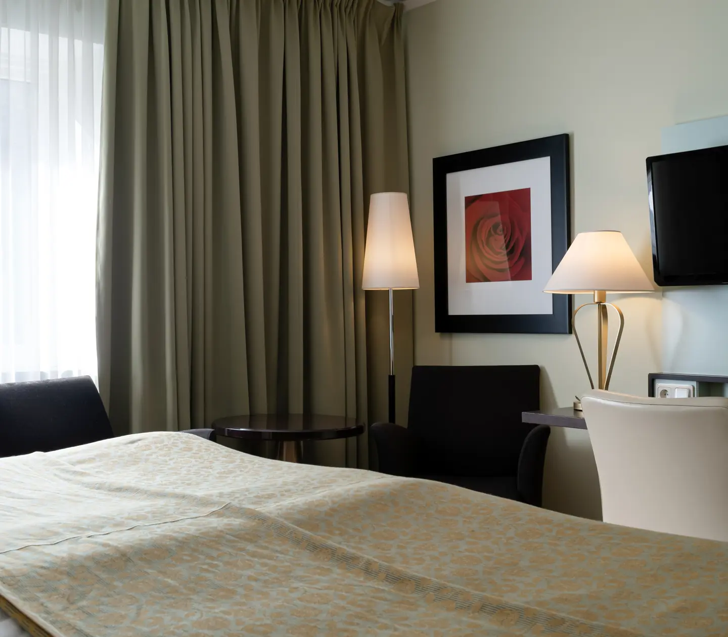 Hotellrum med tv, fåtöljer och skrivbord