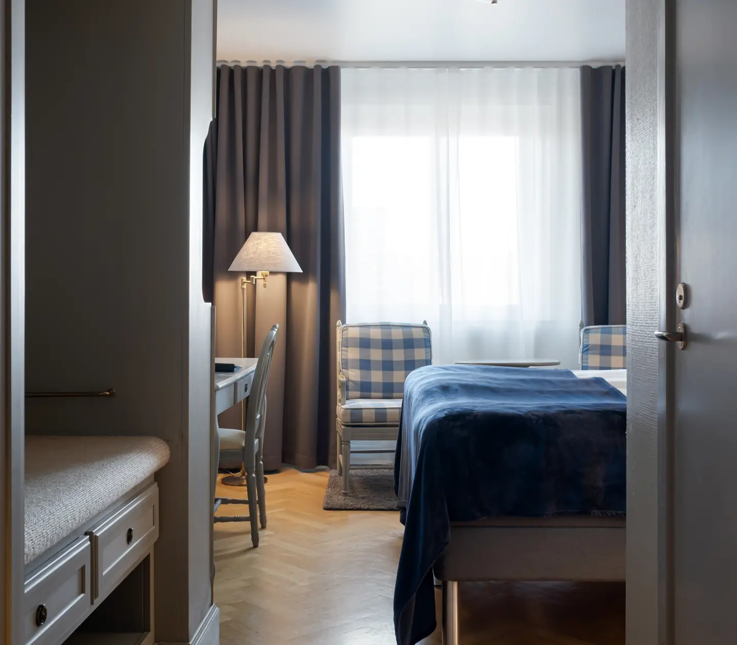 Hotellrum med säng, fåtöljer och skrivbord