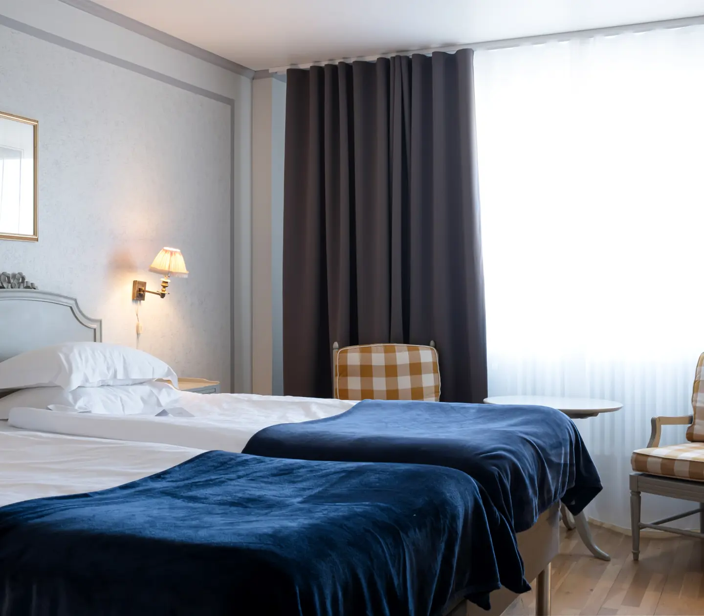 Hotellrum med säng, fåtöljer och fönster