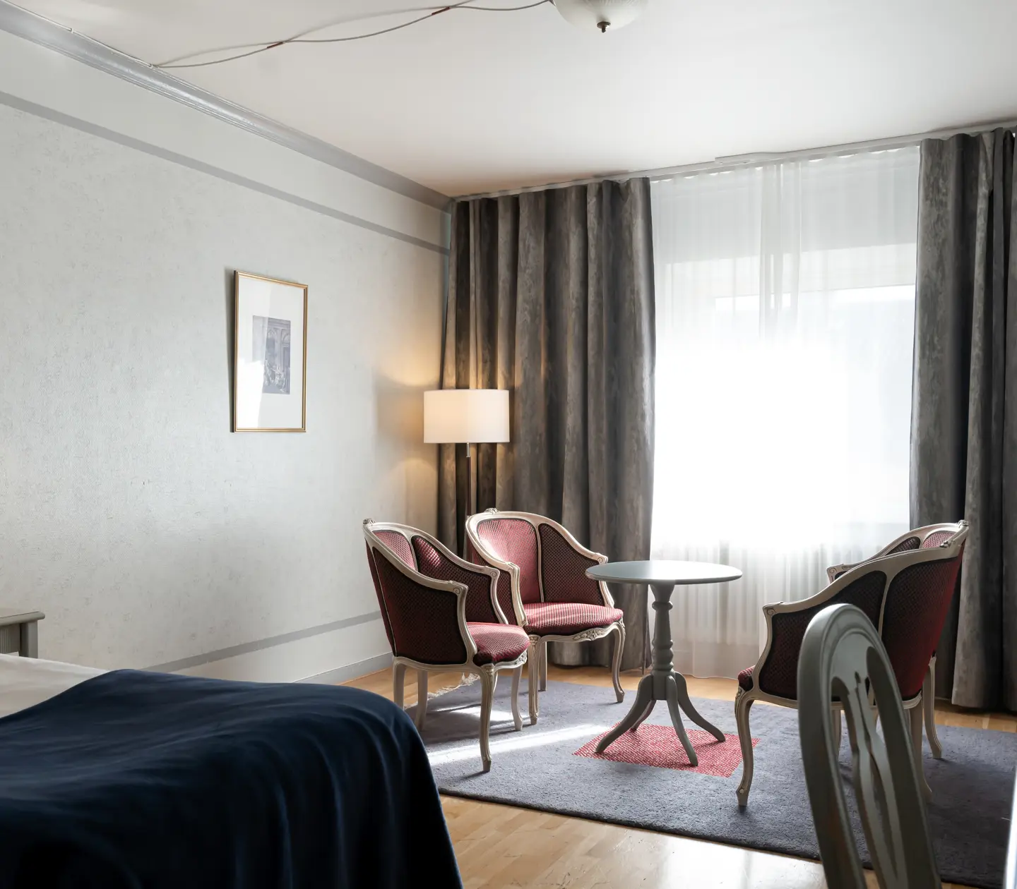 Hotellrum med säng, sittgrupp och fönster