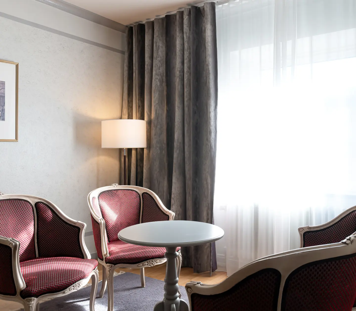 Hotellrum med sittgrupp, tavla och fönster