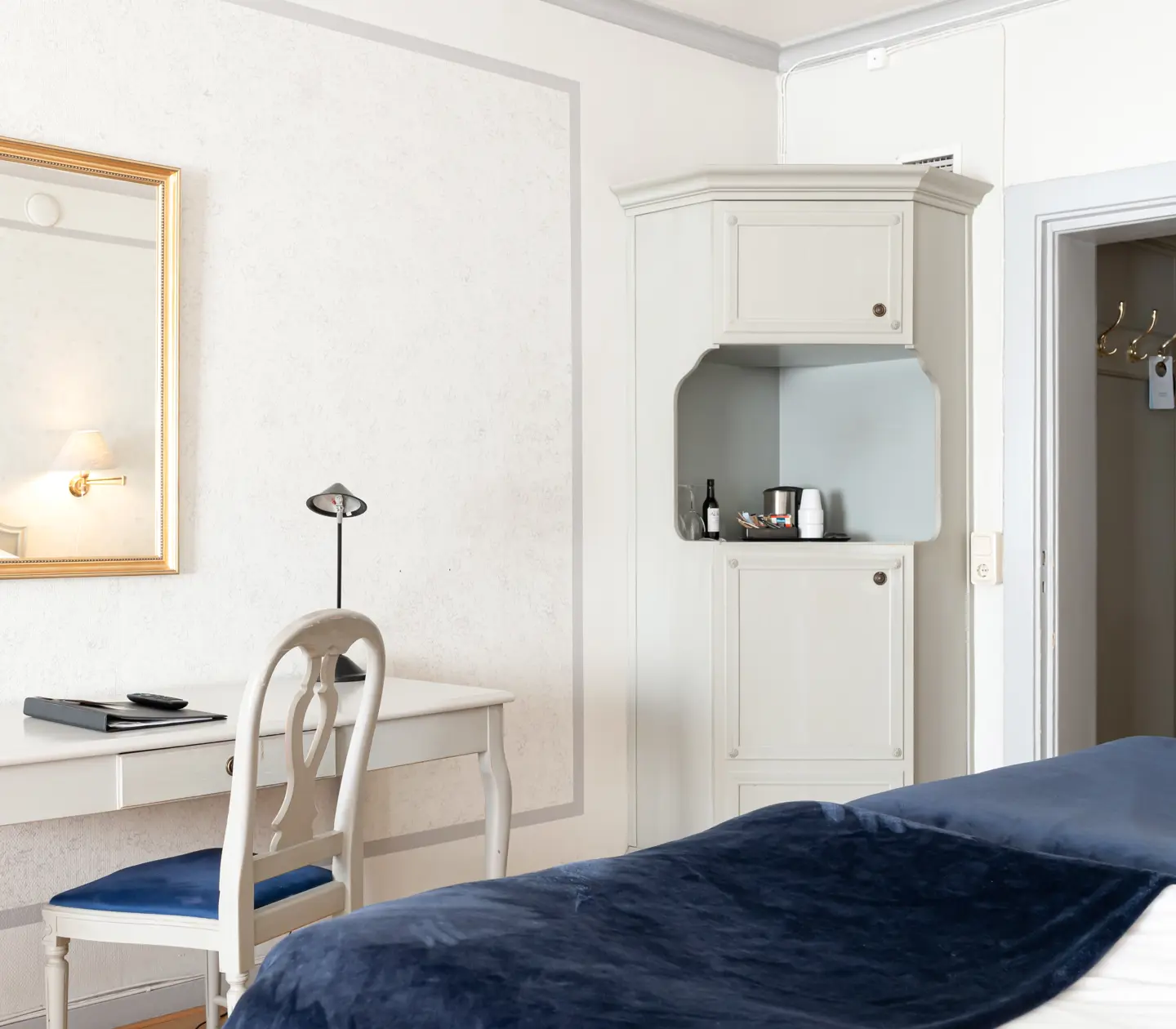 Hotellrum med säng, skrivbord och spegel