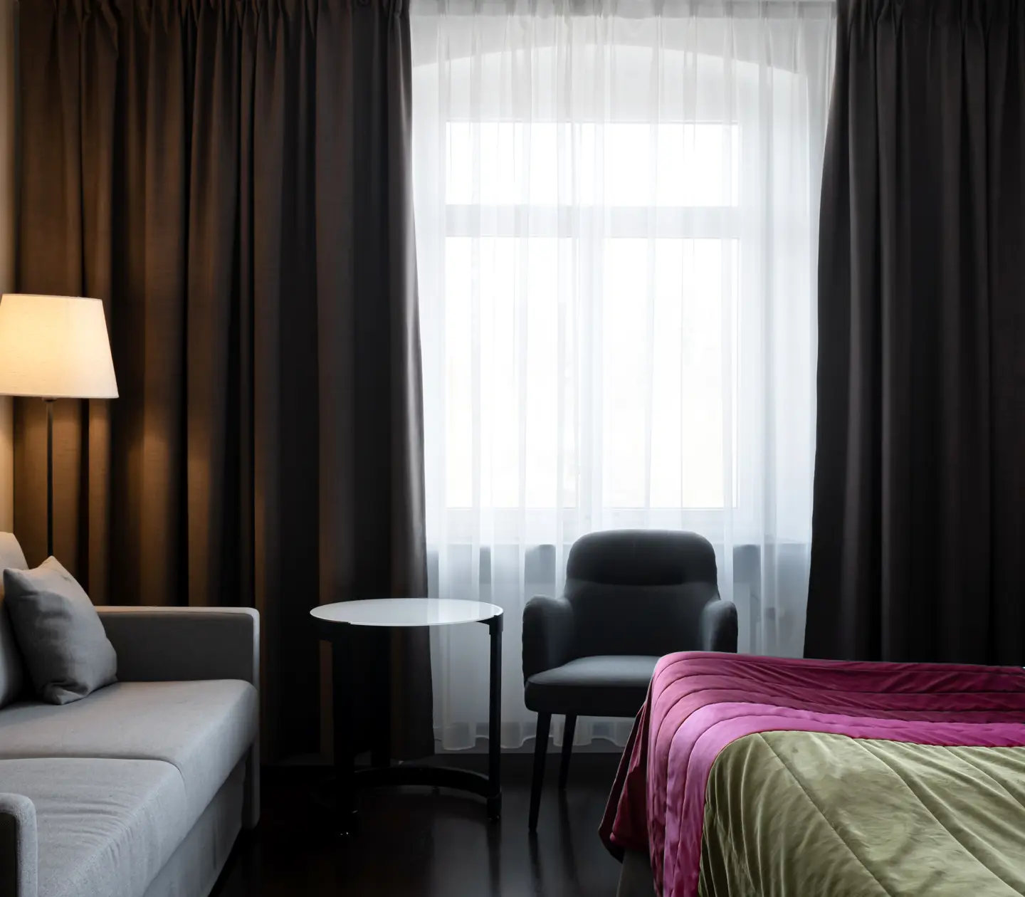 Hotellrum med säng, soffa och fönster