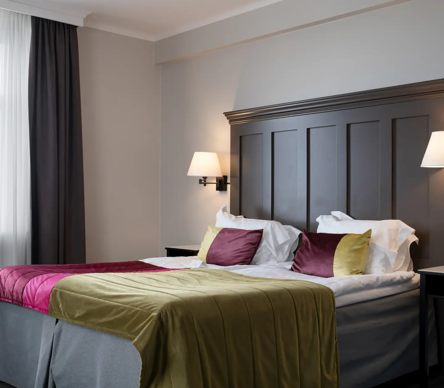 Hotellrum med säng, stor sänggavel i trä och havsutsikt