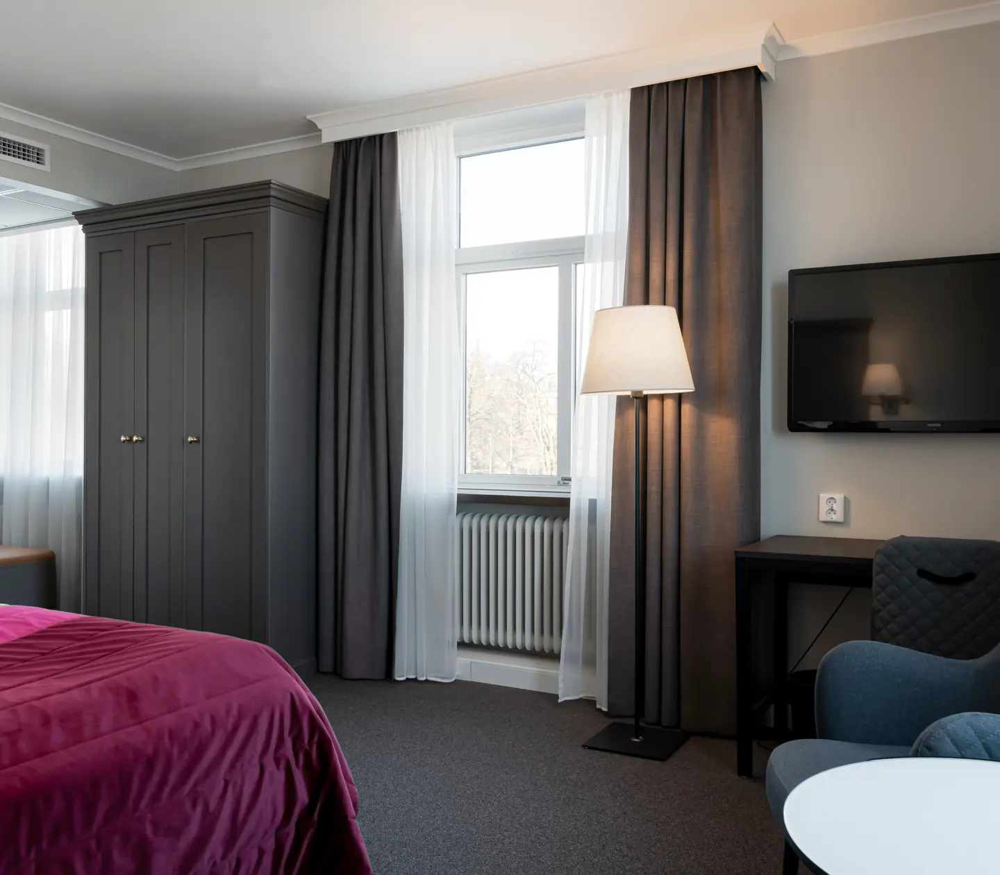 Hotellrum med skrivbord, fönster och garderob
