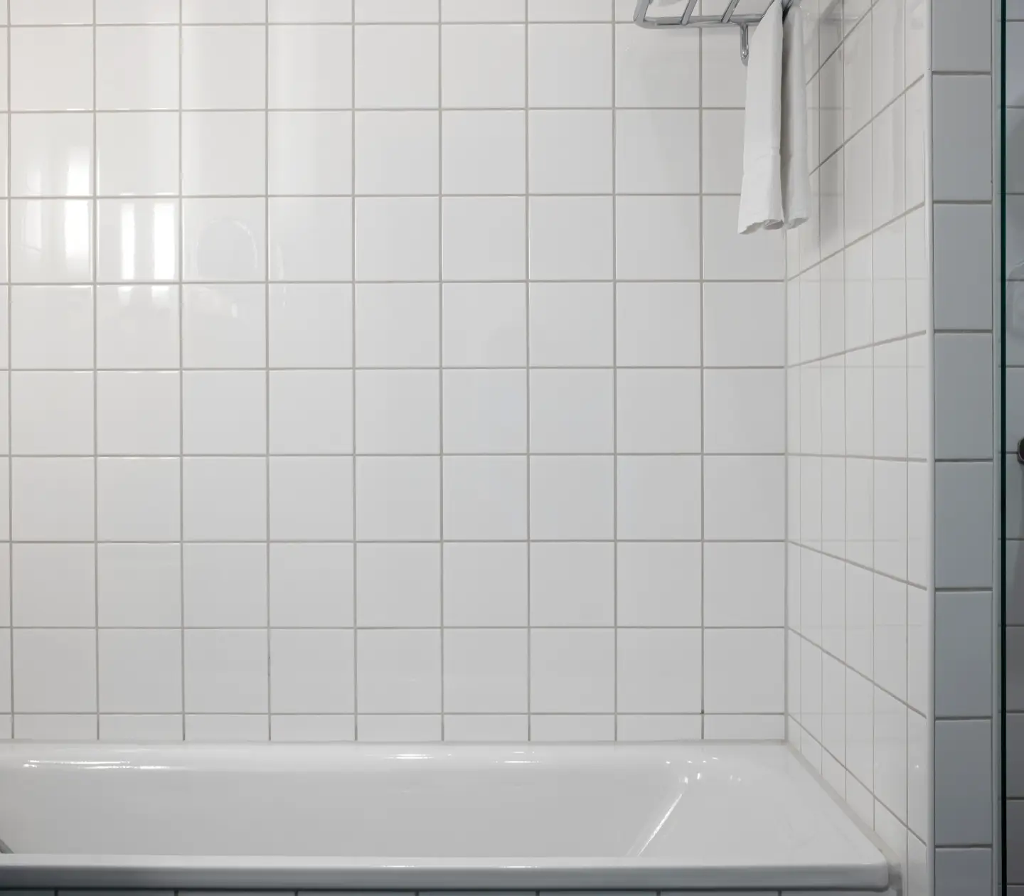 Ljust badrum med badkar, dusch och handdukar