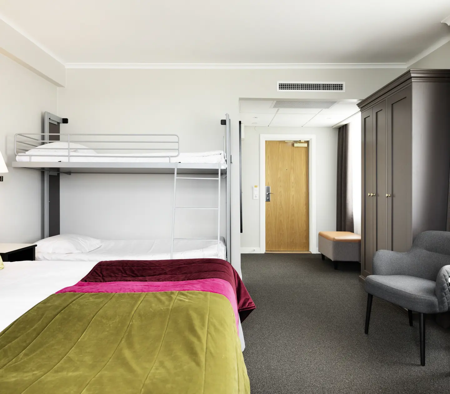 Hotellrum med säng, våningssäng och garderob