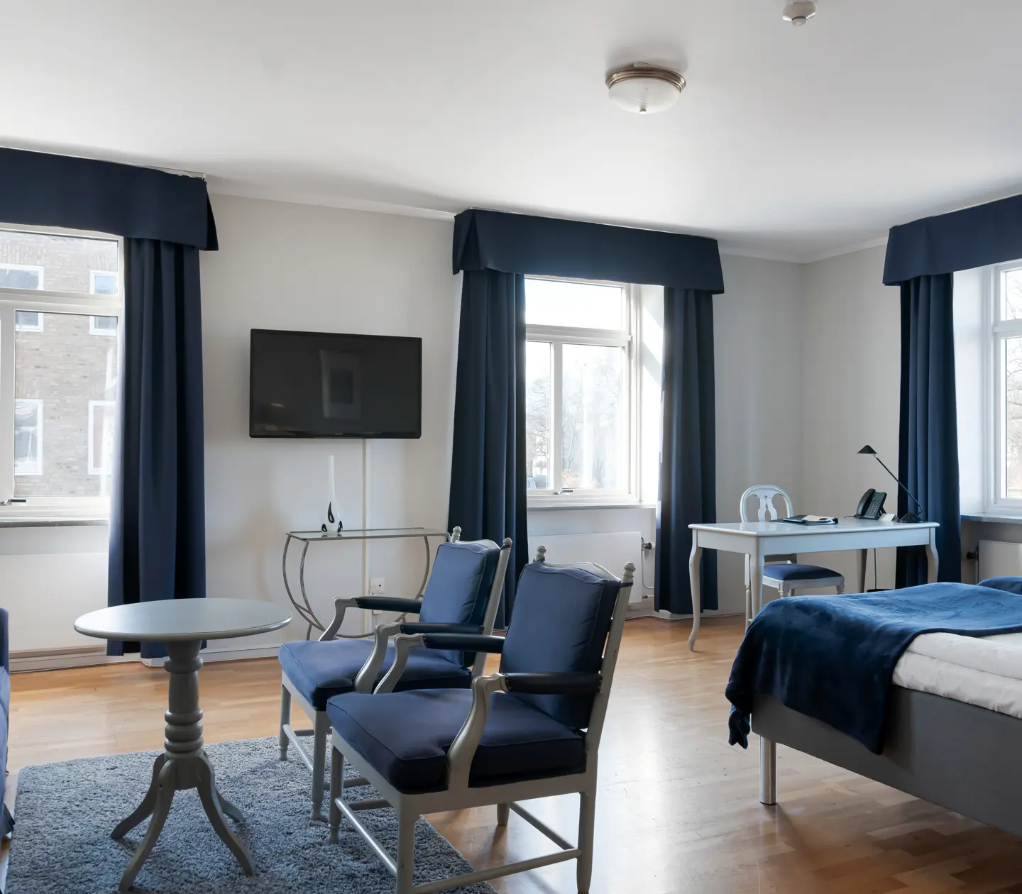 Hotellrum med sittgrupp och skrivbord och fönster