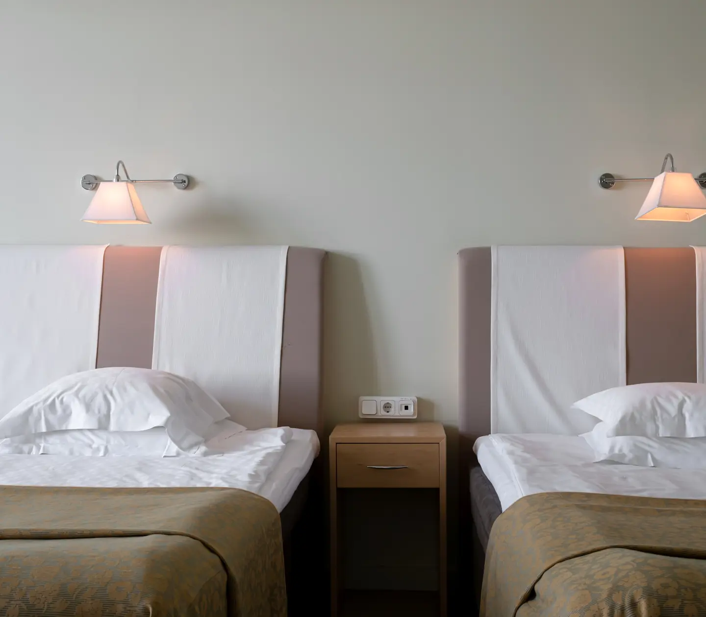 Hotellrum med sängar, nattduksbord och sänglampor