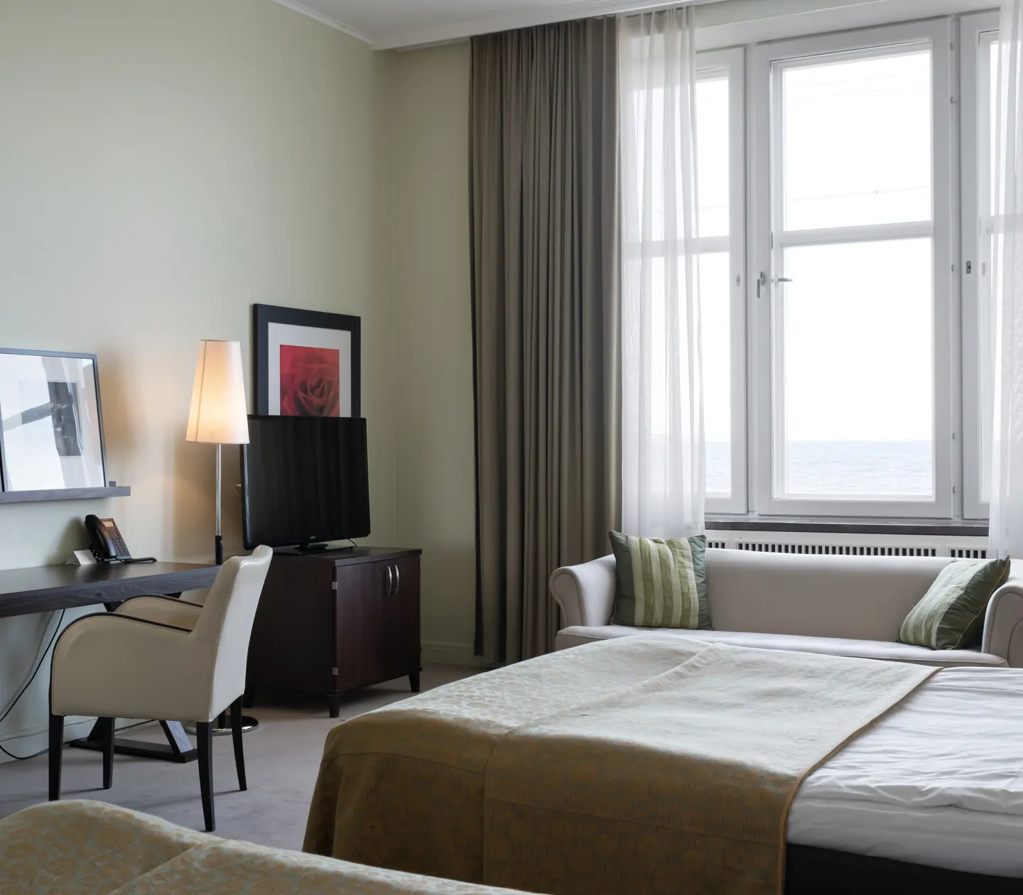 Hotellrum med sängar, skrivbord och fönster