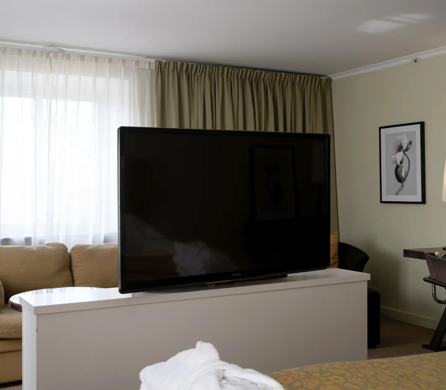 Svit med tv, skrivbord och stort fönster