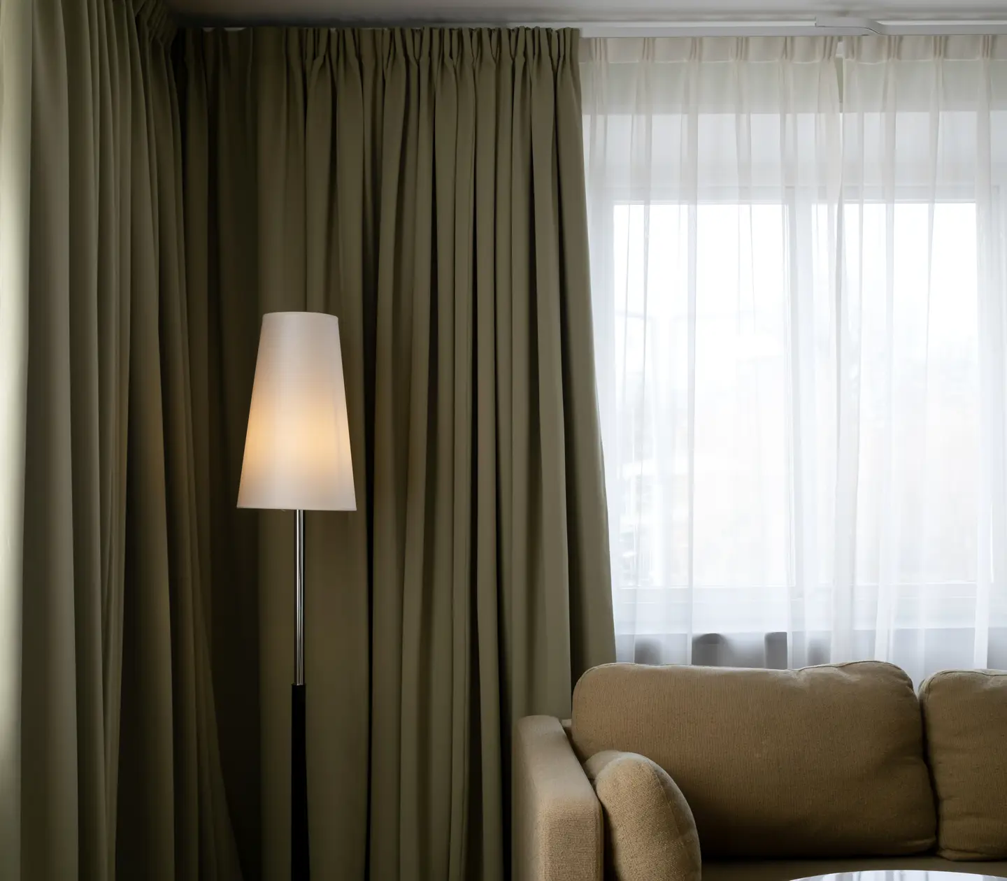 Svit med soffa, golvlampa och stort fönster
