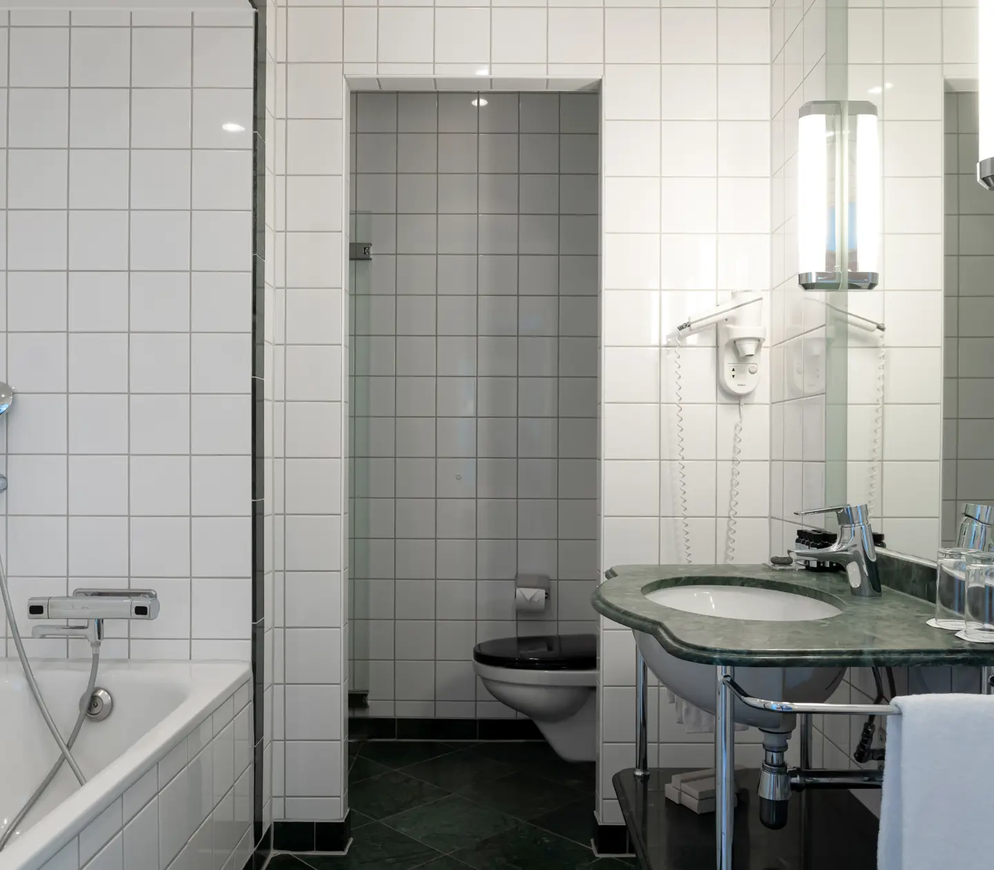 Ljust badrum med badkar, toalett och handfat