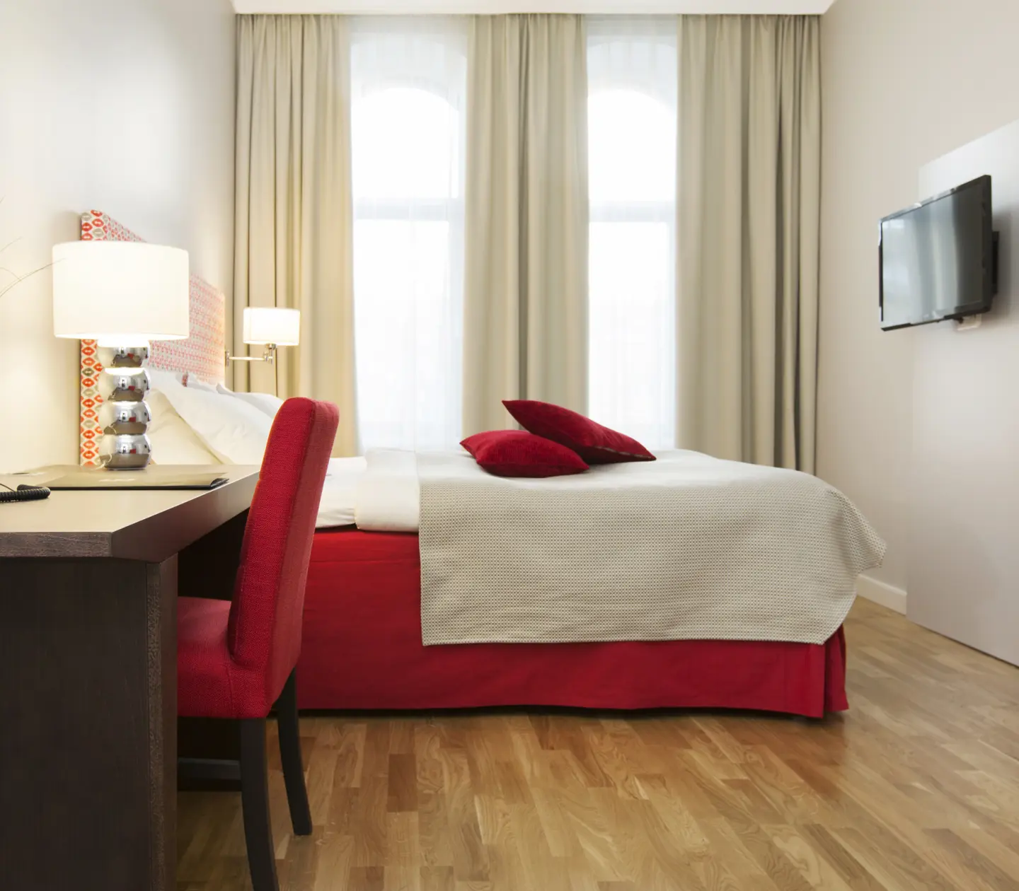Hotellrum med dubbelsäng, skrivbord och tv