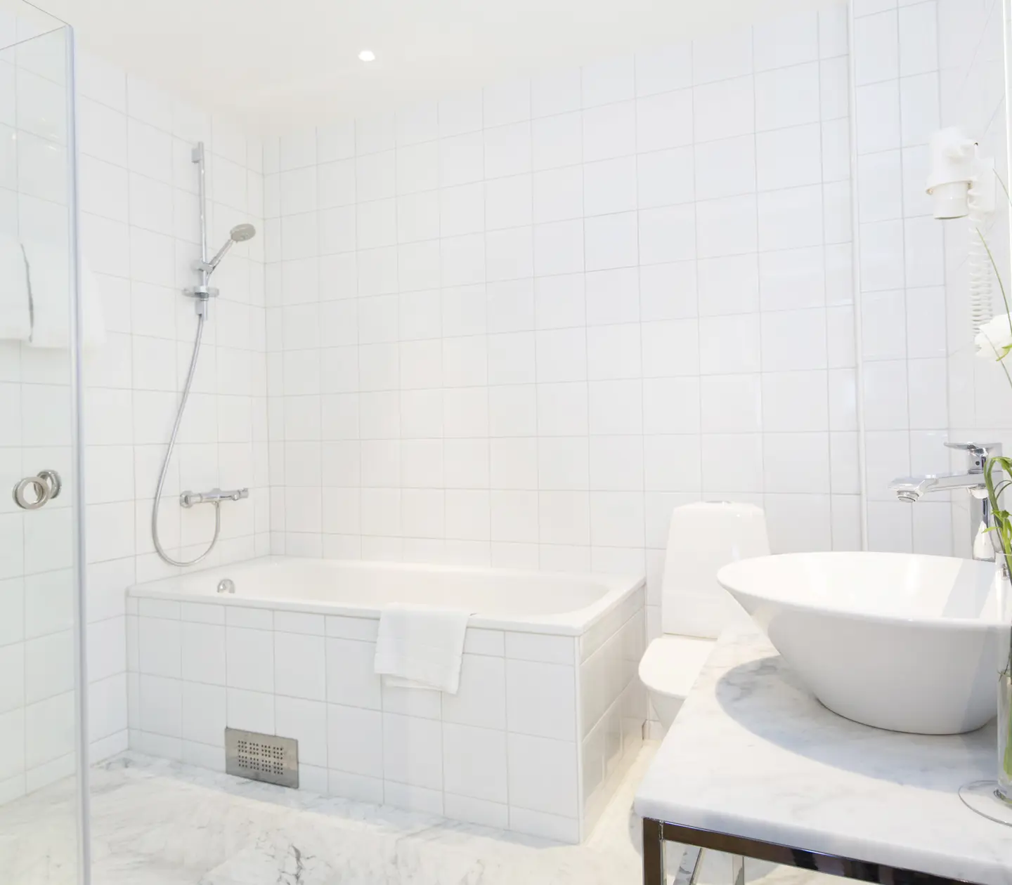 Ljust badrum med handfat, toalett och badkar