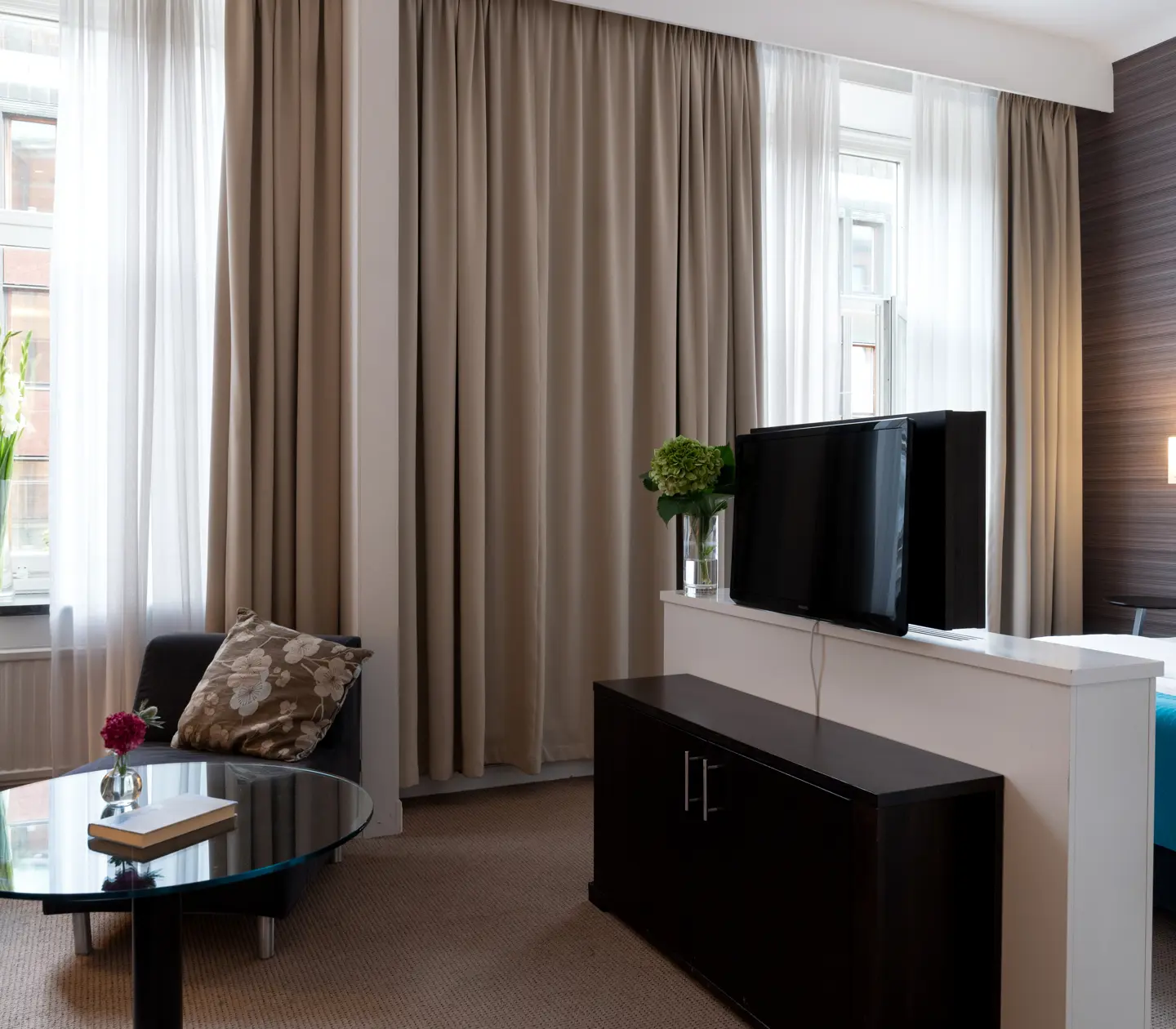 Hotellrum med dubbelsäng, sänglampor och öppen balkongdörr