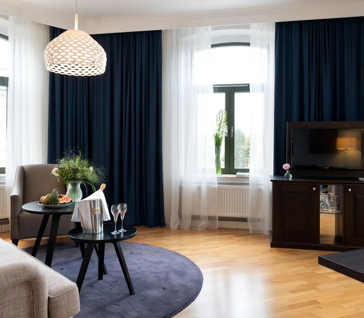 Mysig svit med soffa, tv och stora fönster