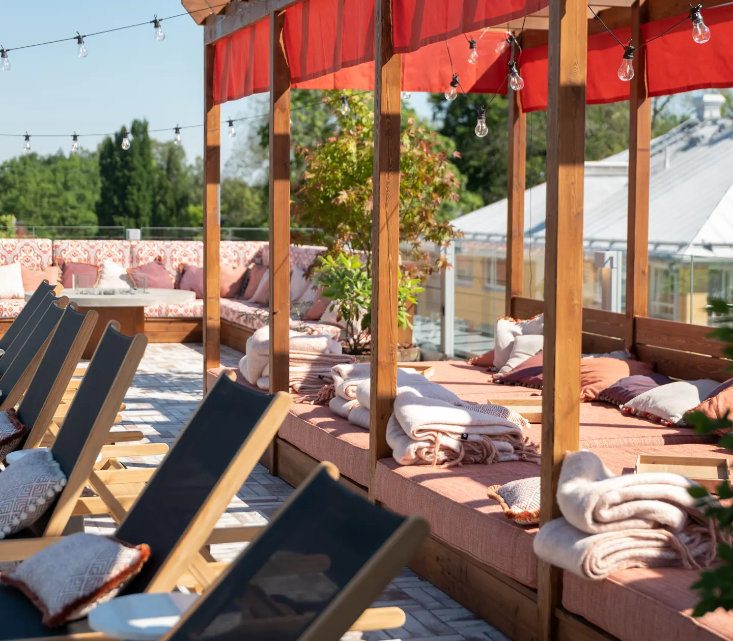 Takterass med solsängar och loungemöbler