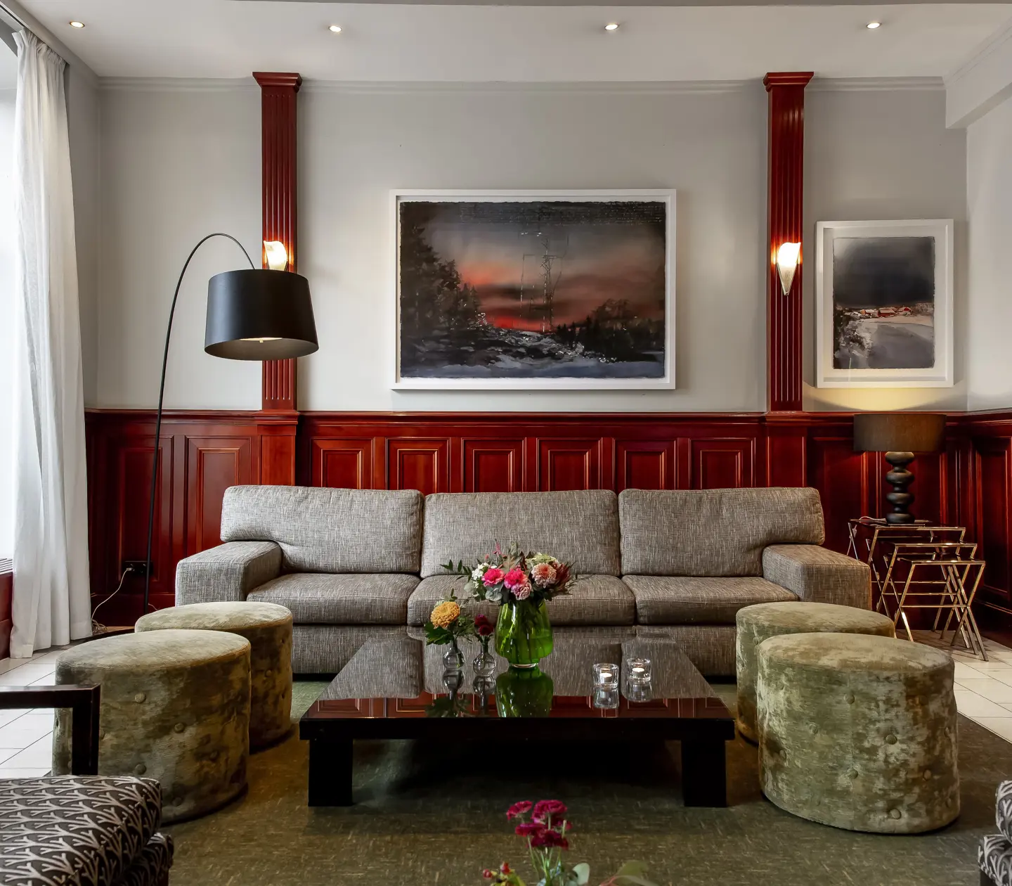 Ombonad hotellobby med soffgrupp, tavlor och lampor