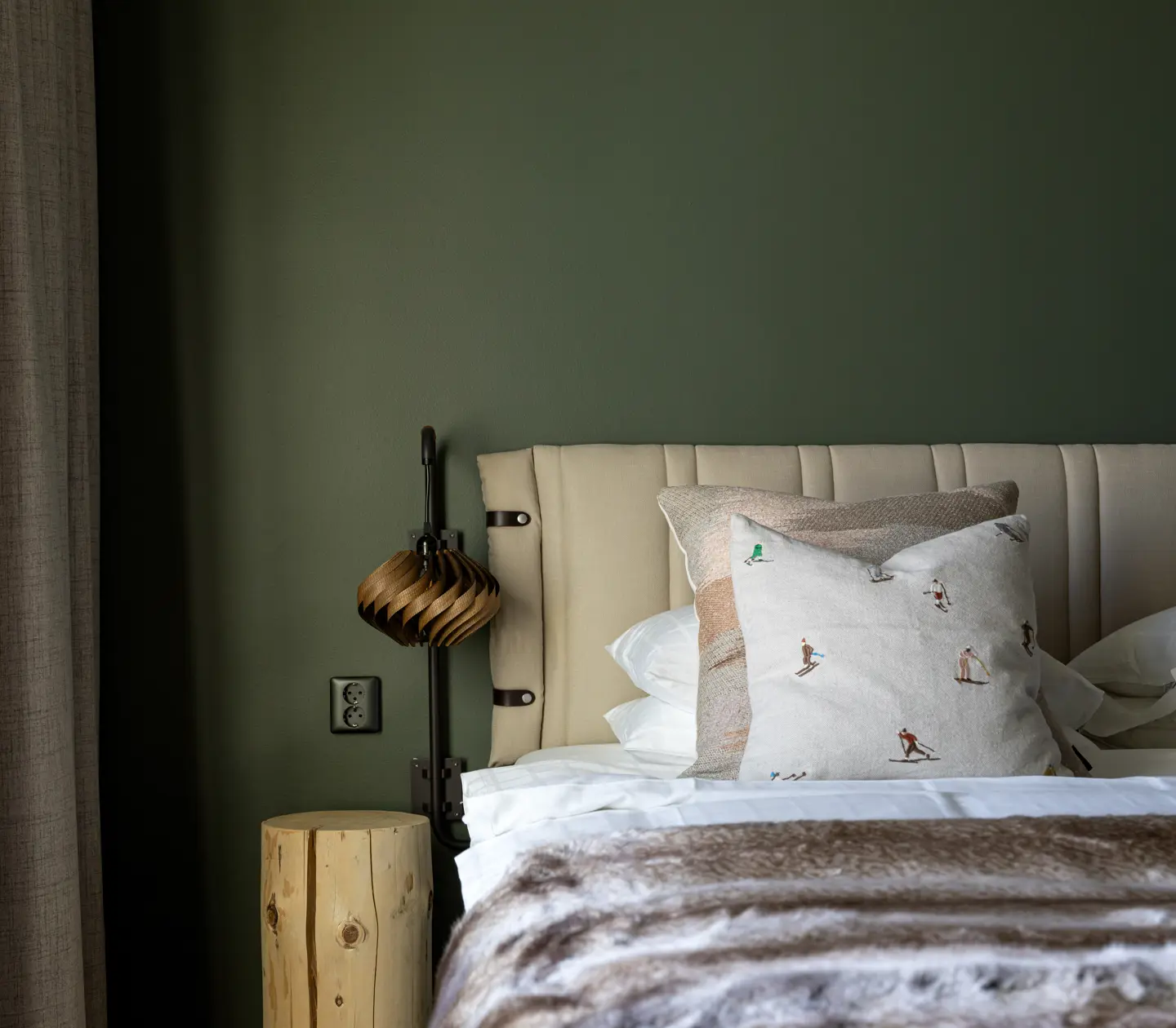 Grönt hotellrum med säng och sängbord