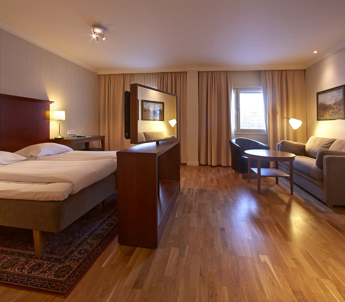 Mysigt hotellrum med säng, soffa och fönster