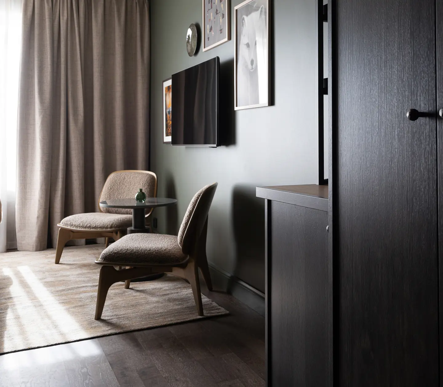 Mysigt hotellrum med säng, taklampa, fönster och fåtöljer