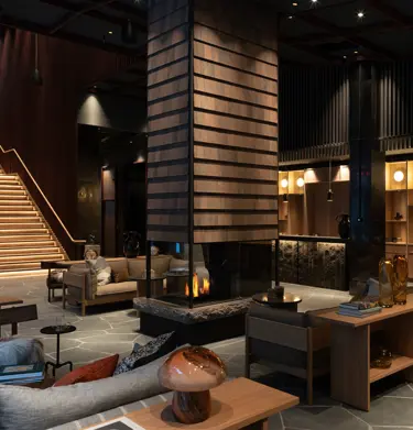 Mysig hotellobby med mycket sittplatser och eldstad i mitten