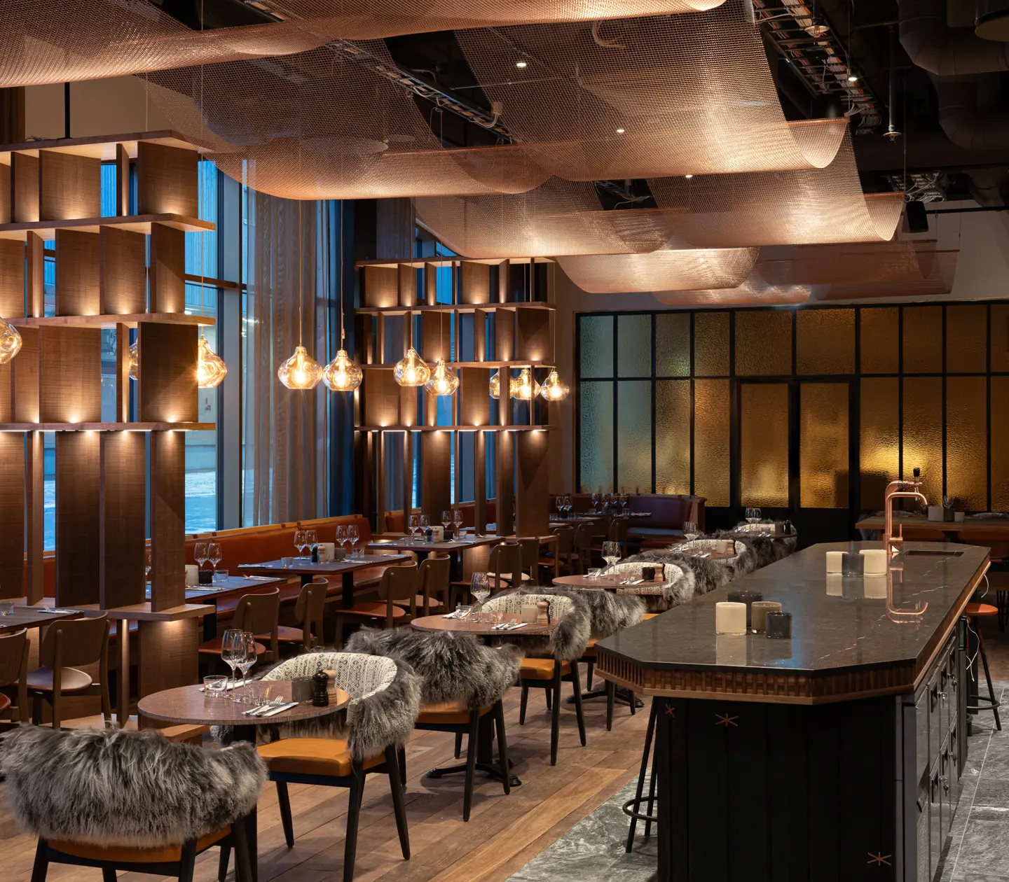 Övergripande bild över Restaurang Fe med flera sittplatser klädda i plädar med segel i koppar i taket