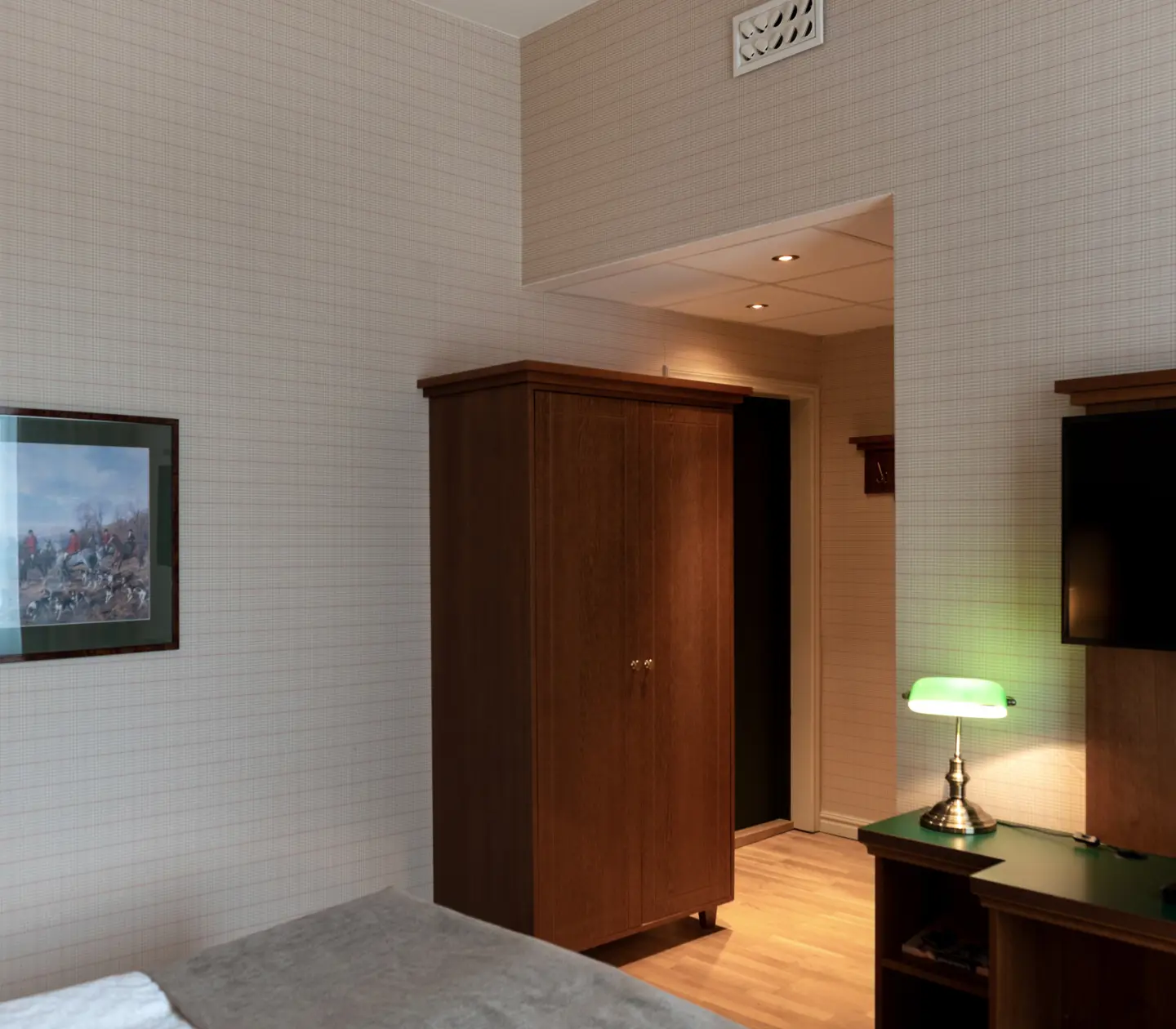 Hotellrum med garderob, tavla och tv
