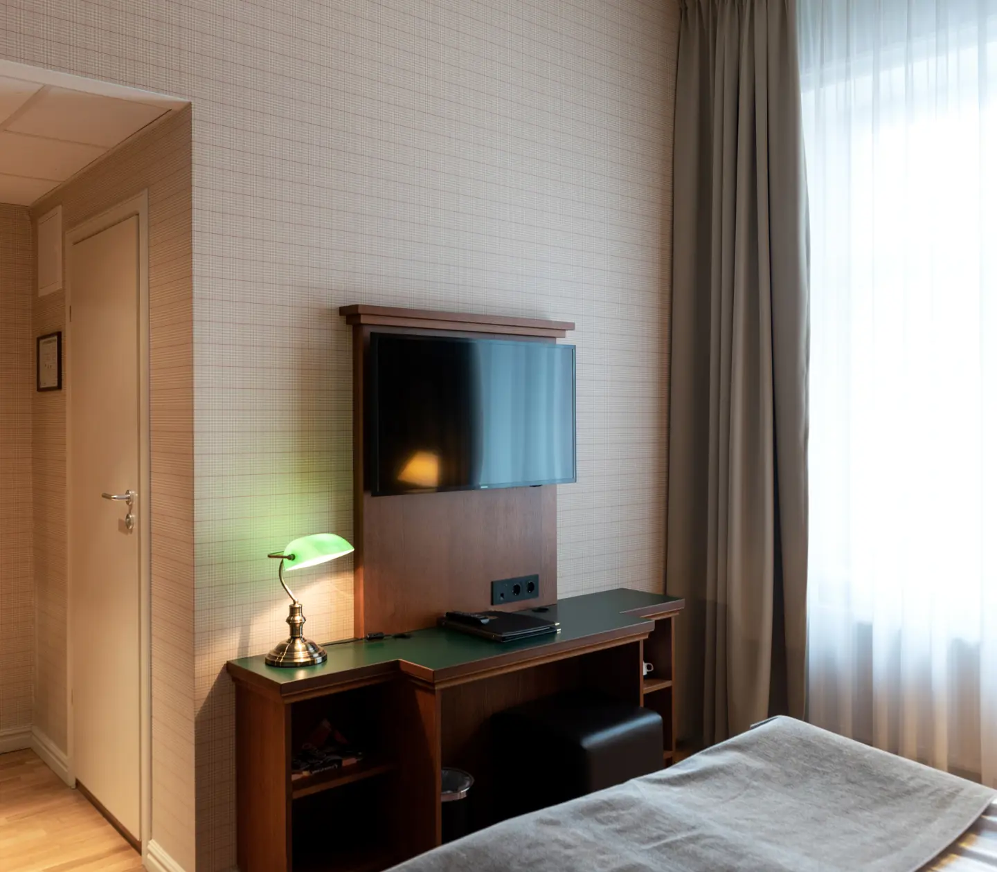 Hotellrum med spegel, skrivbord och tv