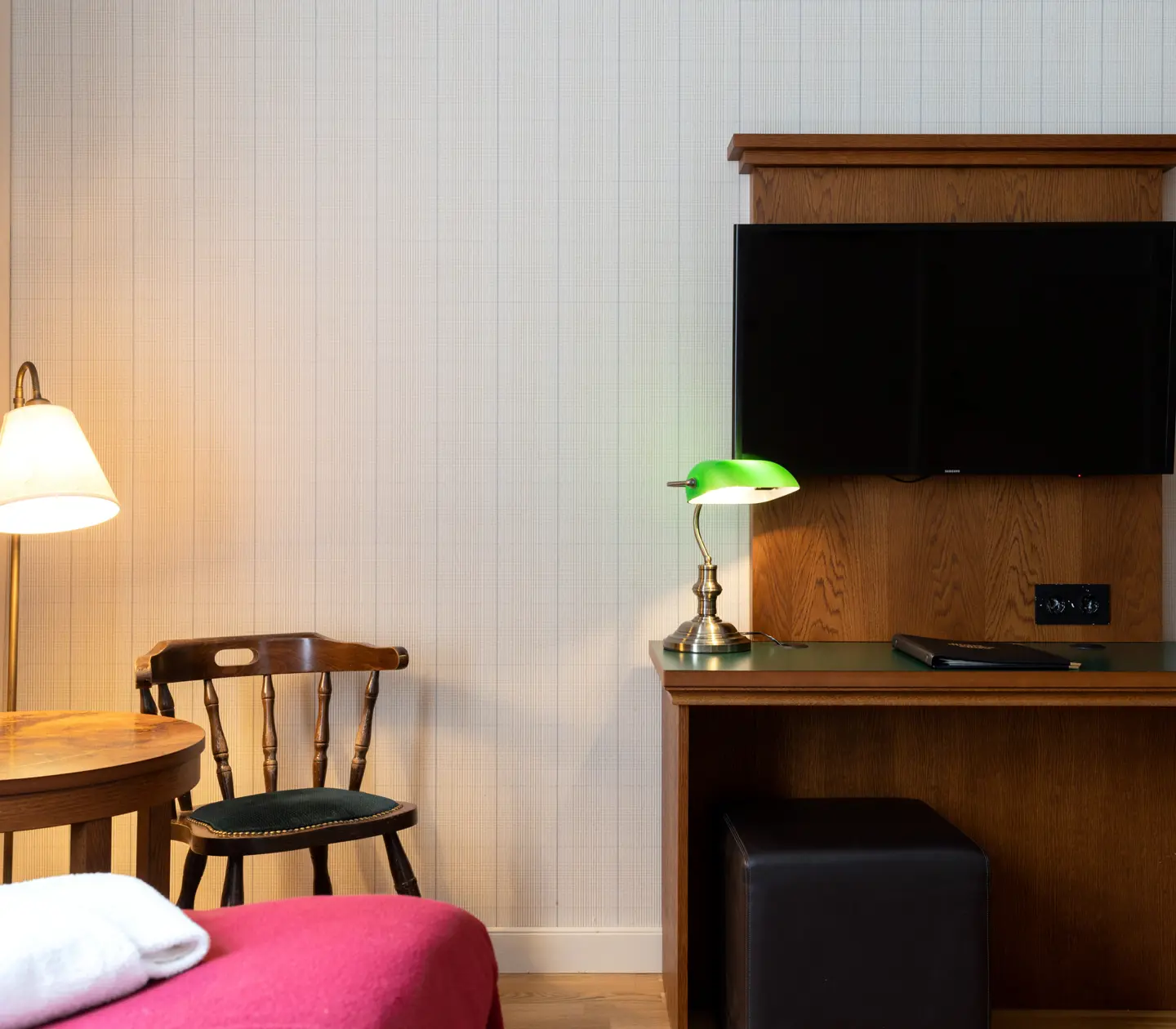 Mysigt hotellrum med stol, skrivbord och tv