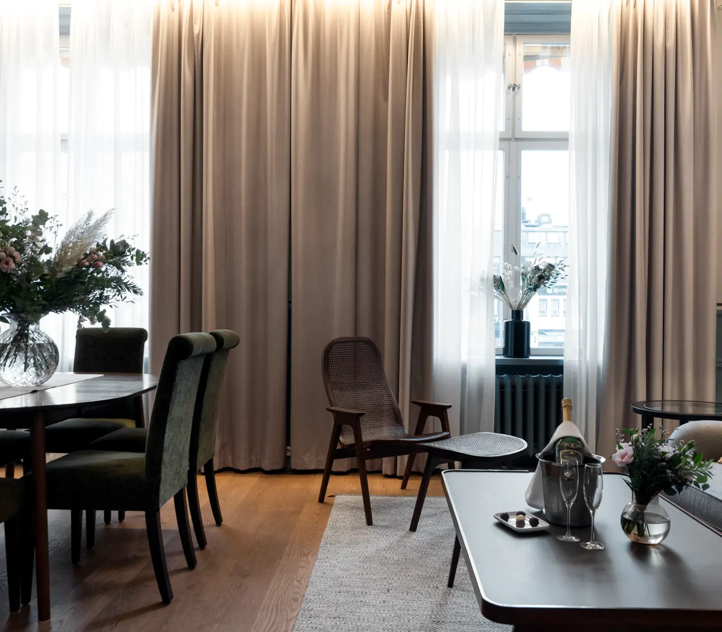 Svit med matbord, sittgrupp och stora fönster