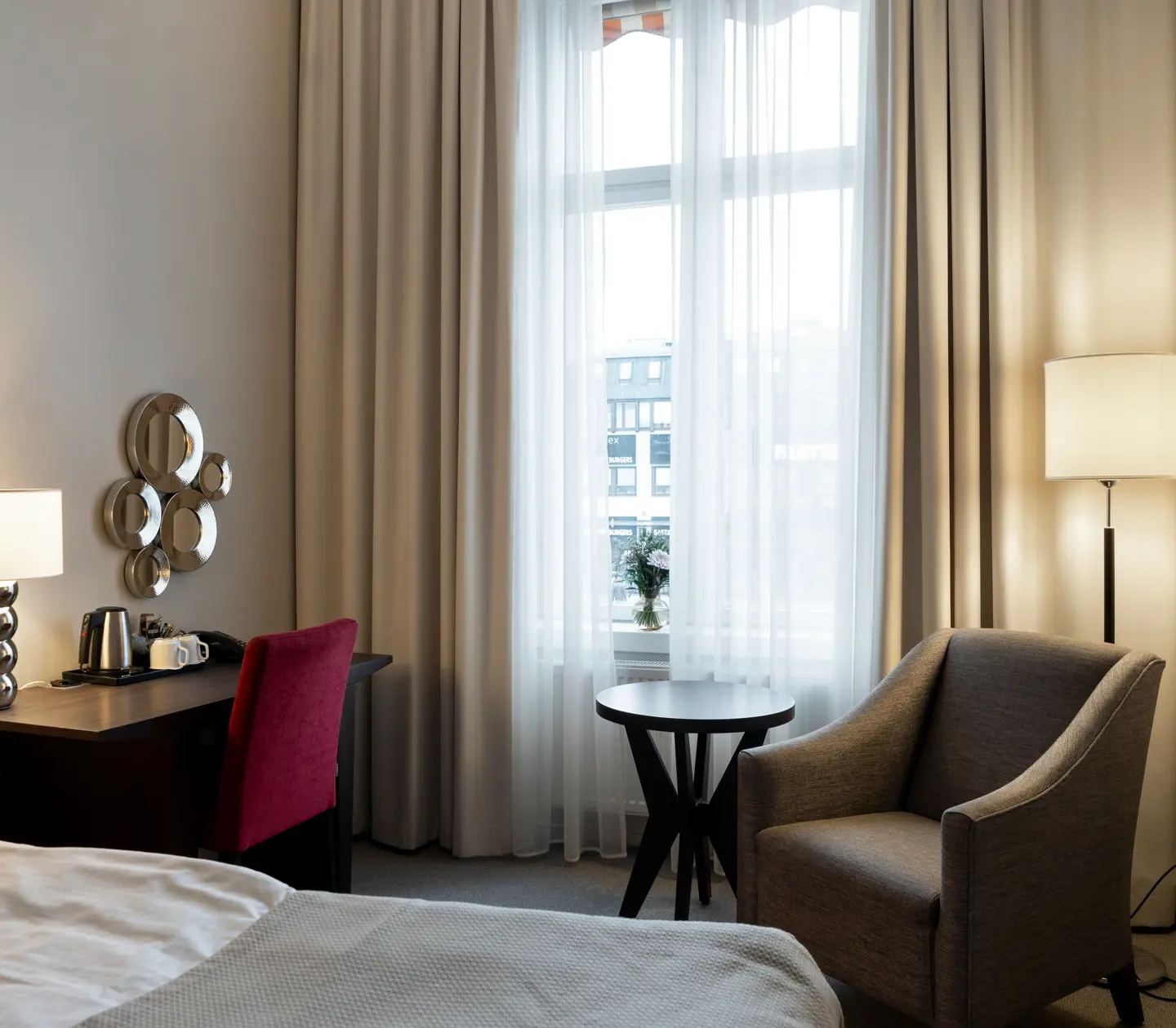 Hotellrum med dubbelsäng, skrivbord och fönster