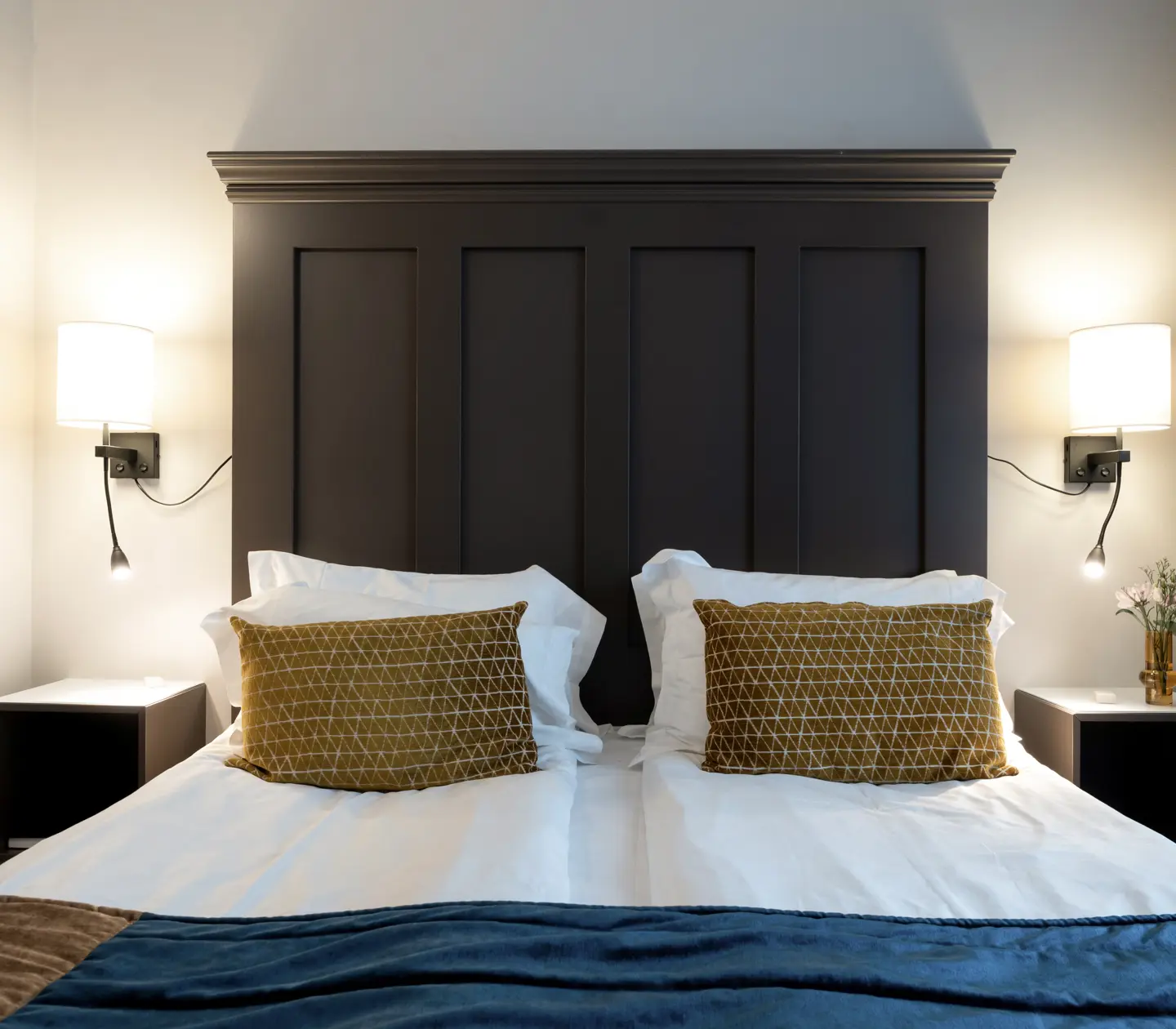 Hotellrum med dubbelsäng, tavla och sänglampor
