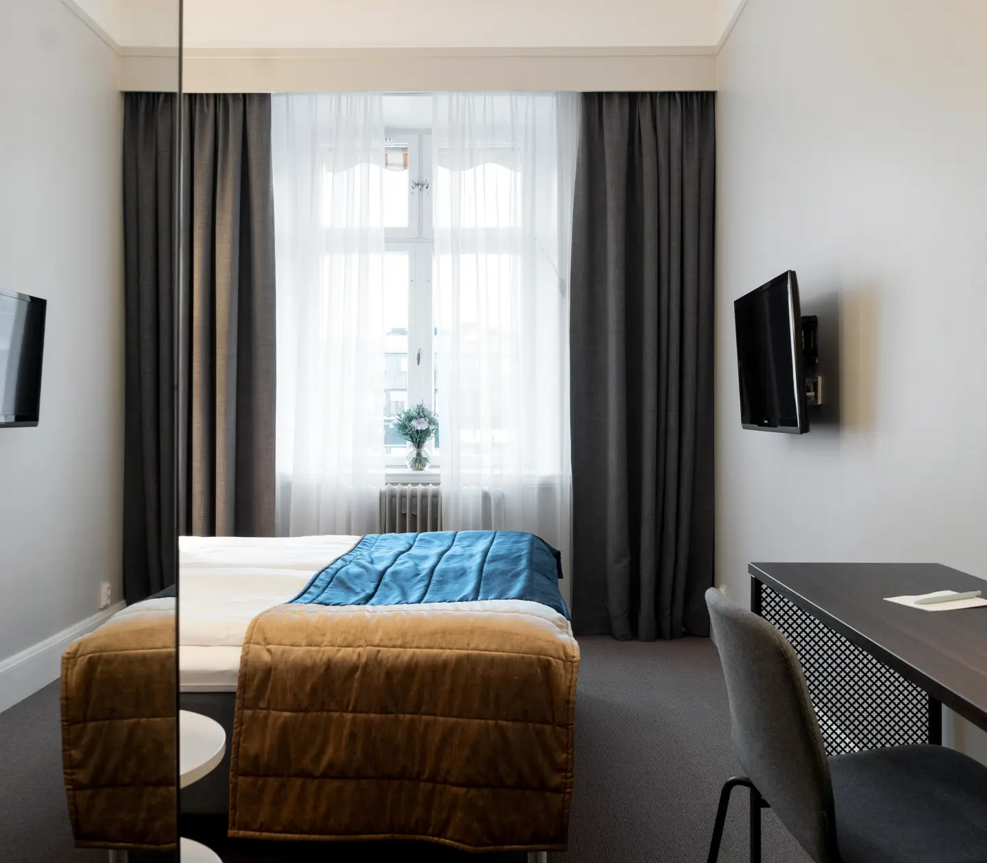Hotellrum med fönster, skrivbord och tv